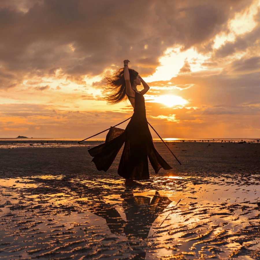 Frau bewegt sich auf ihre einzigartige Art am Meer, symbolisiert tiefe Human Design Ausbildung für Coaches und Beraterinnen.